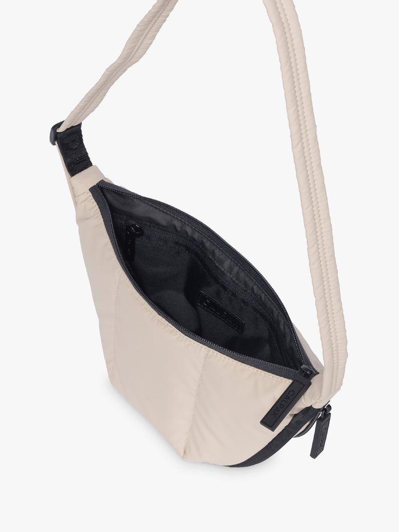 Opened CALPAK Luka Crescent Bag in beige off white Oatmeal