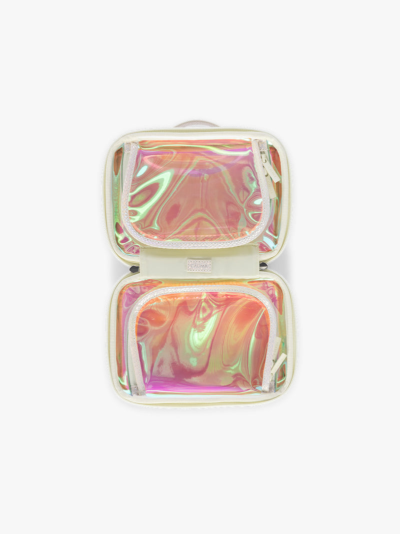 Opened view of Person wearing beige holding a CALPAK Small Clear Cosmetic Case in Moonbeam with white border and transparent holographic iridescent makeup bag on a white background