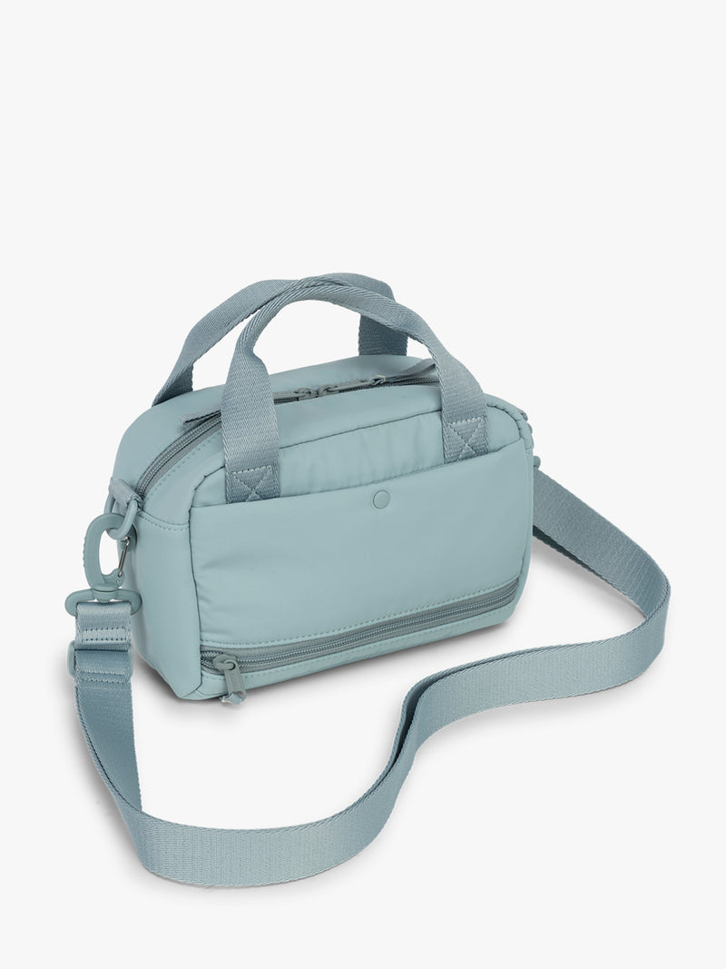 CALPAK Connect Crossbody Bag in beige light blue Bluebell with a shoulder strap on a white background