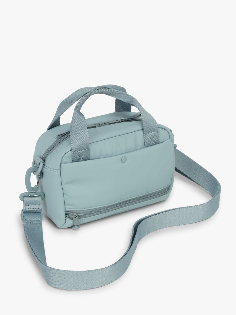 CALPAK Connect Crossbody Bag in beige light blue Bluebell with a shoulder strap on a white background