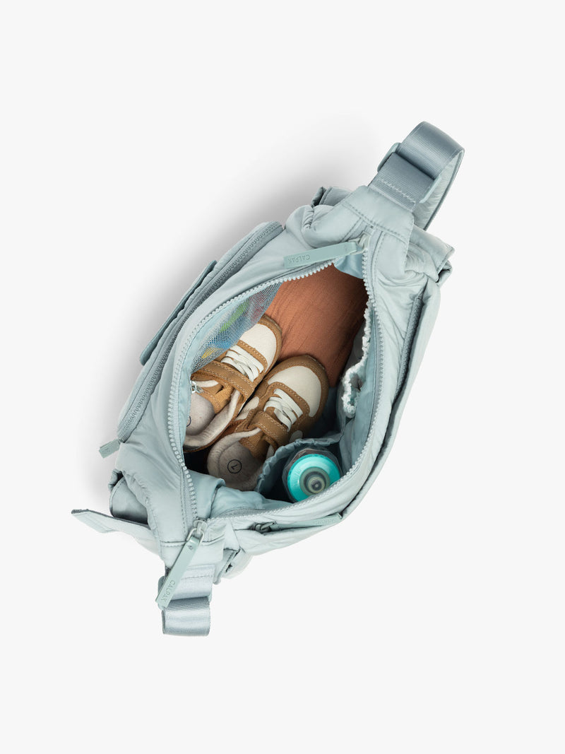 CALPAK Crossbody Diaper Bag in light blue Bluebell top view with zipper opened, showing interior of bag