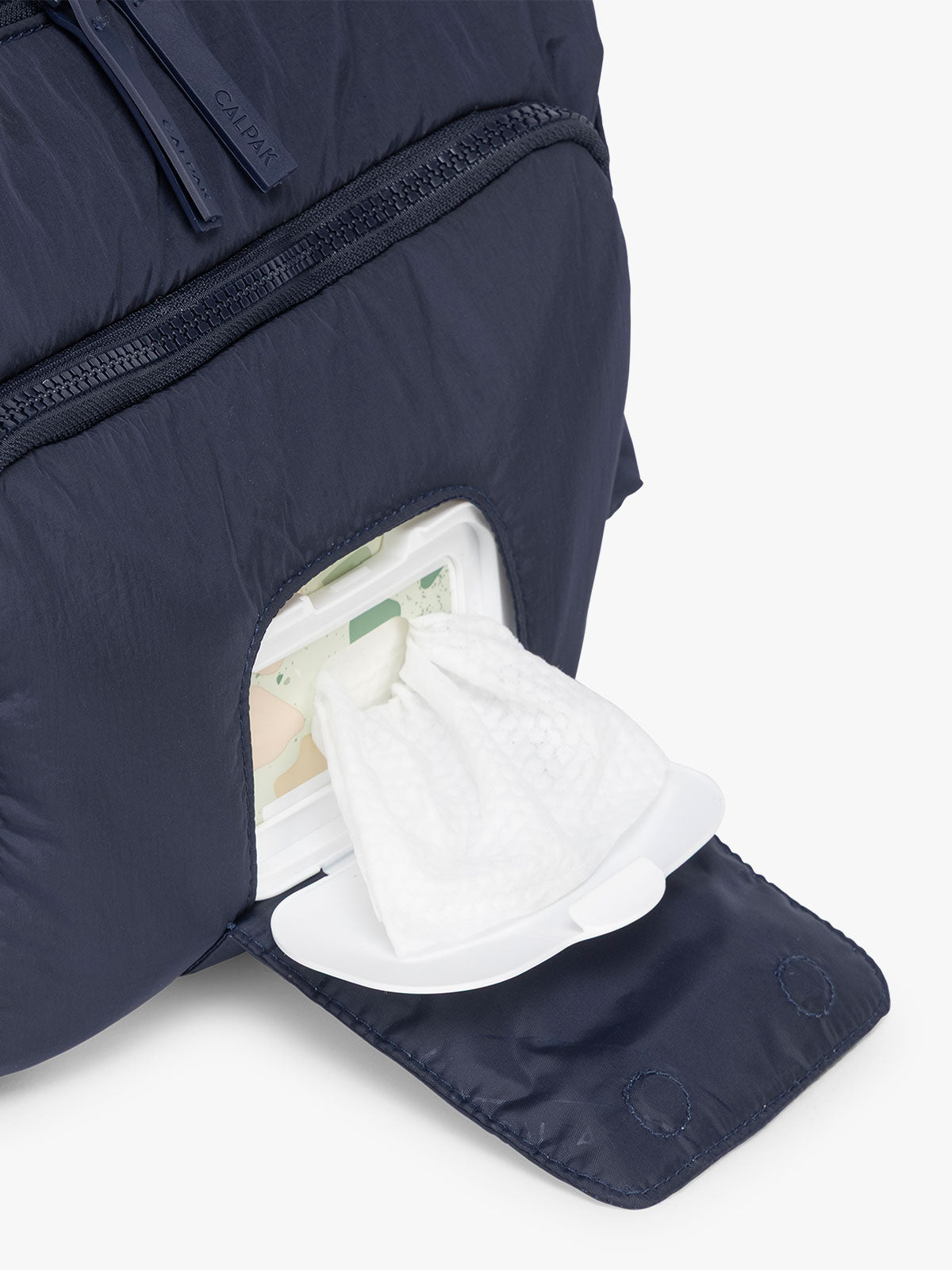 Close up of the front smart wipe compartment of the CALPAK Crossbody Diaper Bag in blue Navy; CDB2501-NAVY