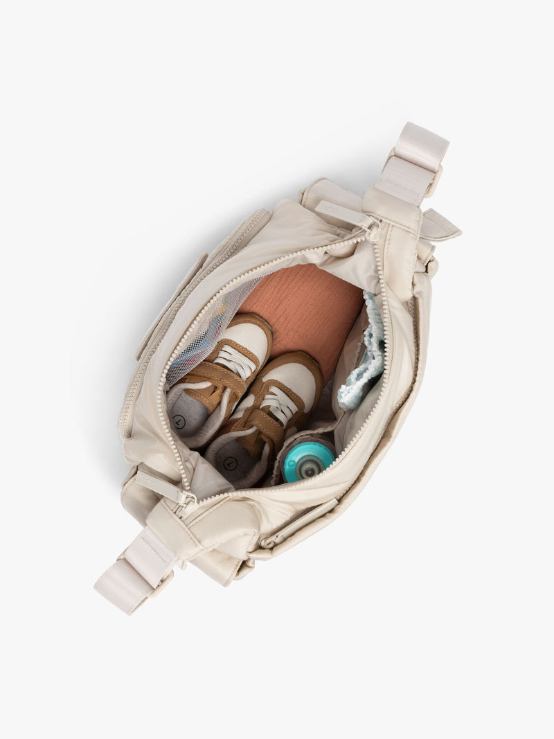 CALPAK Crossbody Diaper Bag in off-white Oatmeal top view with zipper opened, showing interior of bag