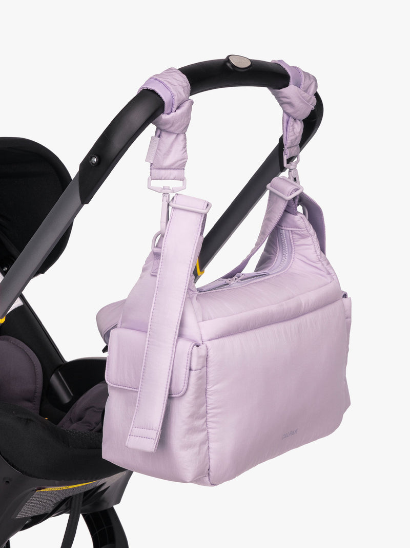 CALPAK Crossbody Diaper Bag in light purple ORCHID strapped on stroller with Stroller Straps