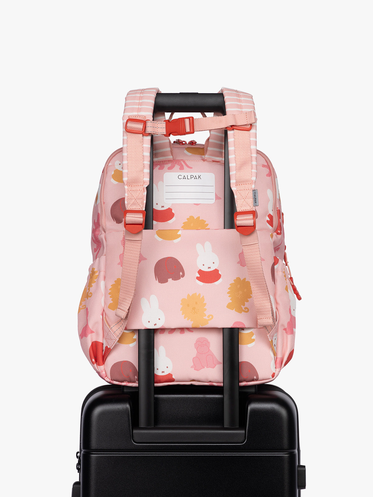 Back luggage trolley sleeve of Side view of CALPAK Kids Large Backpack with Miffy and pink colorful animal pattern on a white background; CKBL2501-MIFFY-PINK-ZOO-TRIP