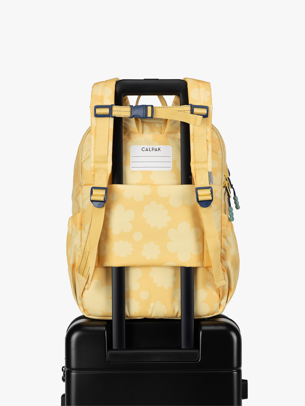 CALPAK Kids Large Backpack in yellow with tan flower print in Yellow Bloom for ages 8-12 with back luggage trolley sleeve; CKBL2501-YELLOW-BLOOM