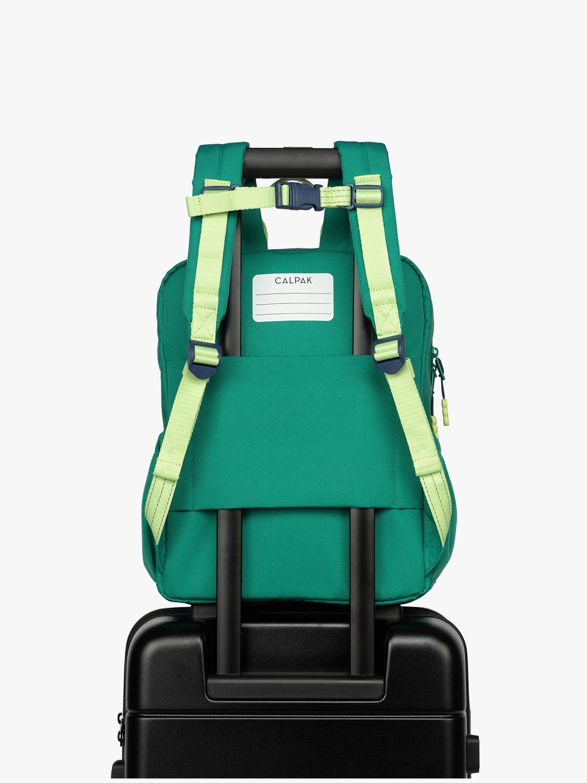 Back view of  luggage trolley sleeve and name tag of the Green CALPAK Kids Medium Backpack with lime green accents on a white background; CKBM2501-GREEN