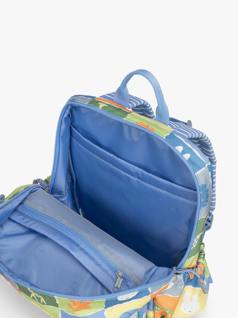 Opened pockets of CALPAK Kids Medium Backpack with Miffy and blue colorful animal pattern on a white background