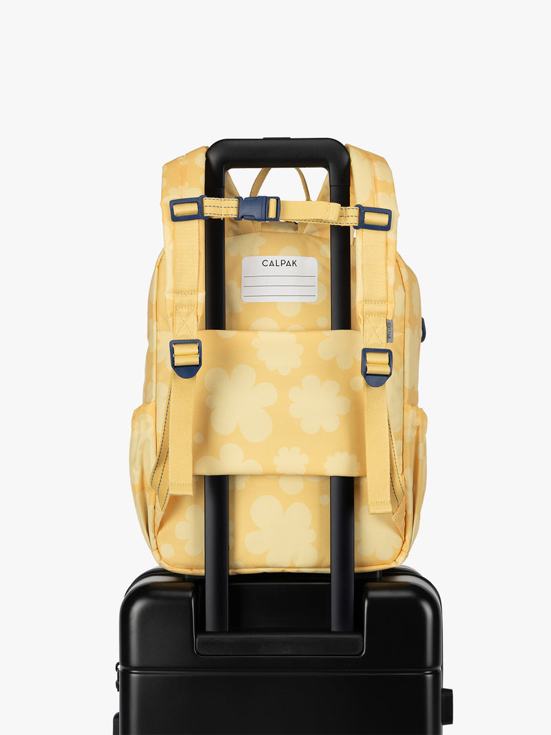 CALPAK Kids Medium Backpack in yellow with tan flower print in Yellow Bloom for ages 5-8 with back luggage trolley sleeve