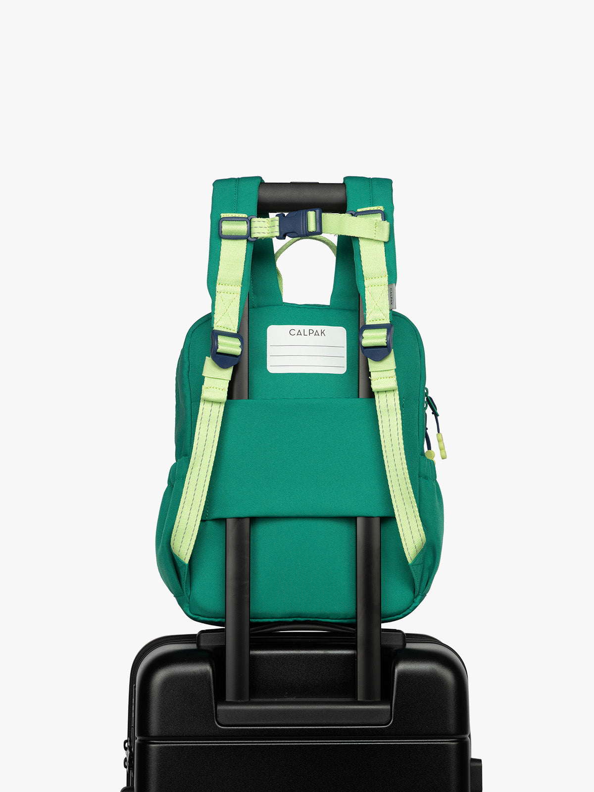 Backside luggage trolley sleeve and nametag of Green CALPAK Kids Small Backpack with lime green accents on a white background; CKBS2501-GREEN