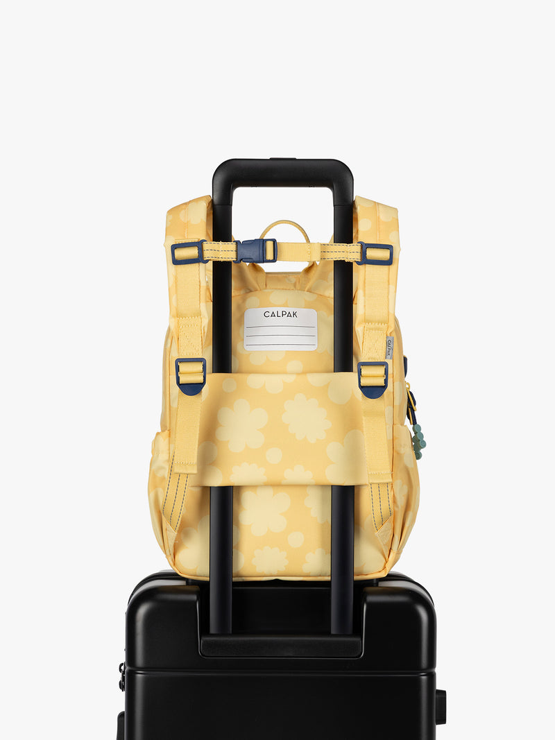 CALPAK Kids Small Backpack in yellow with tan flower print in Yellow Bloom for ages 3-5 with back luggage trolley sleeve