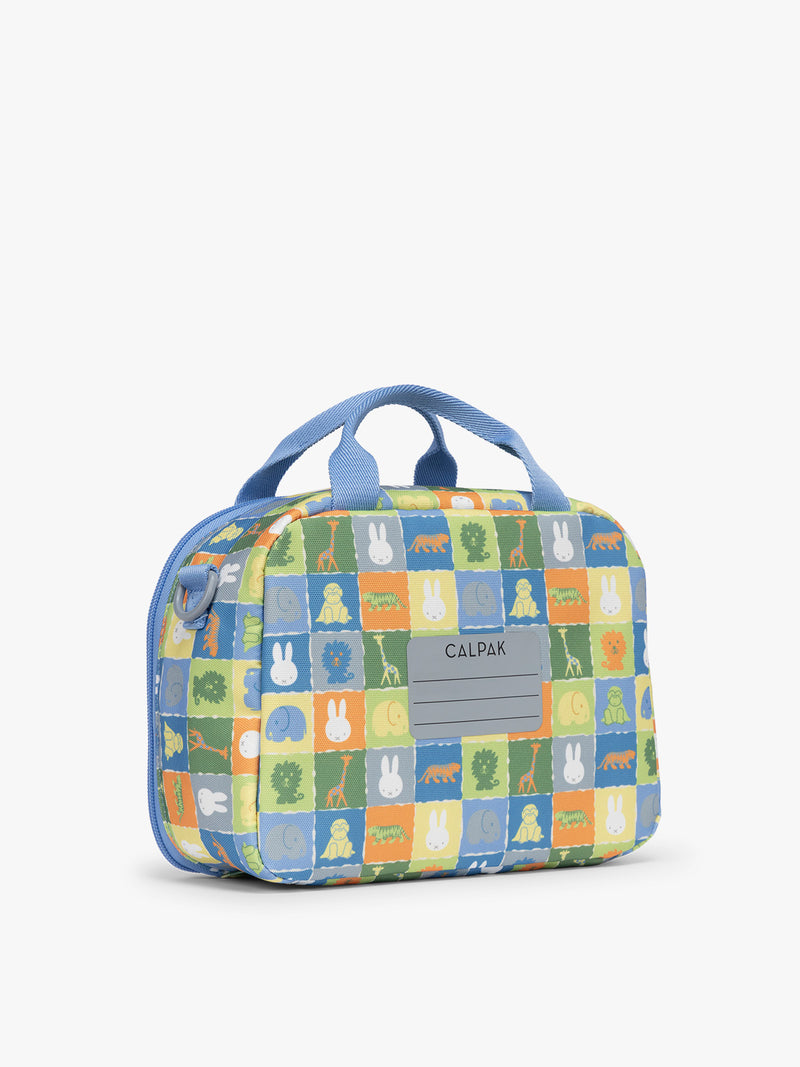 Backside with name label of blue CALPAK Kids Lunch Bag with Miffy and animal pattern with mesh front pocket and top handles on a white background