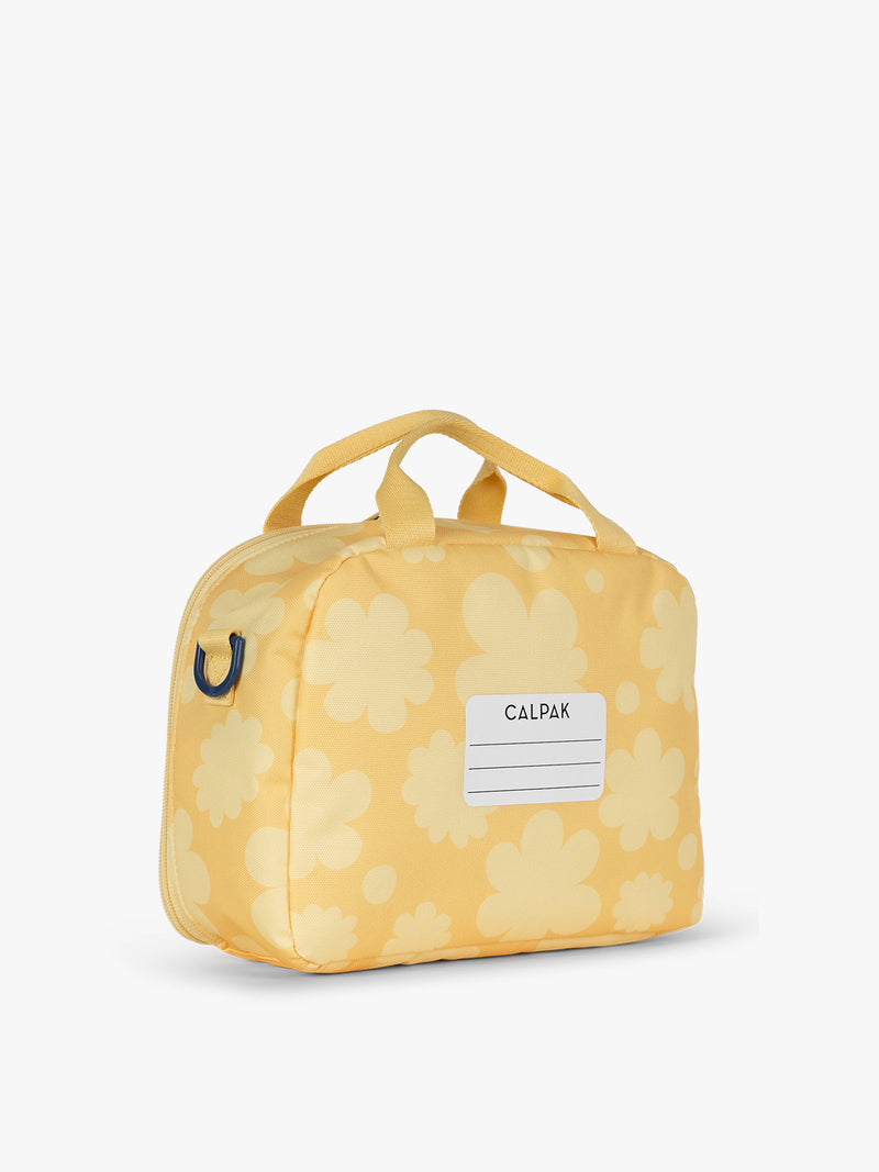 CALPAK Kids Lunch Bag in yellow with tan flower print in Yellow Bloom back view with top handle and name tag section