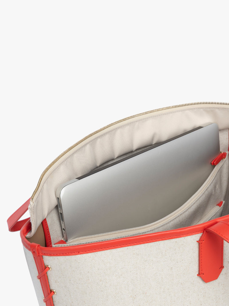 Laptop sleeve of CALPAK Colette 15" Canvas Laptop Tote with zipper and interior laptop sleeve in beige canvas material  with red finishing in Natural Tomato