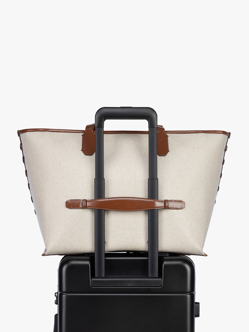 Trolley sleeve of CALPAK Colette 15" Canvas Laptop Tote in beige canvas material  with brown finishing in Natural Brown