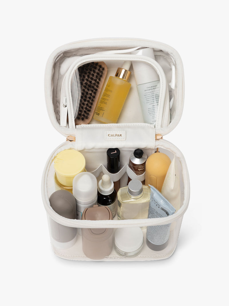 CALPACK Clear Train Case in White, shown as open with toiletries in the top and bottom compartment