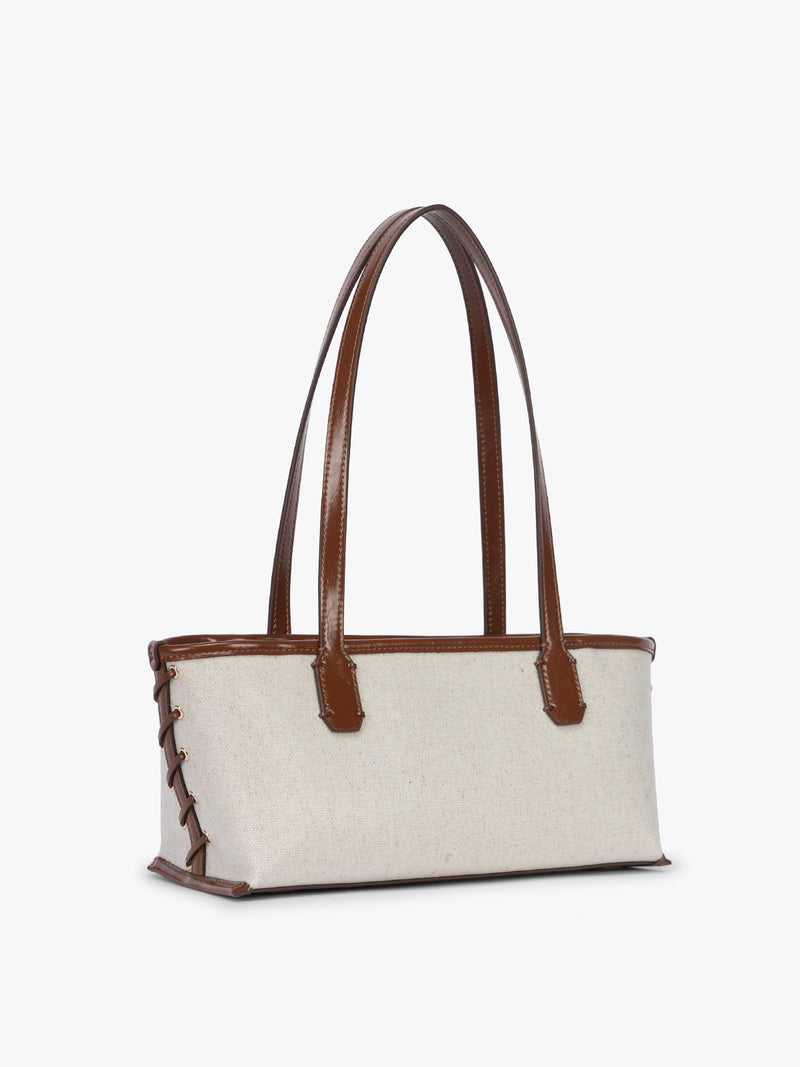 Side view with stitching of CALPAK Colette Canvas Shoulder Tote in beige canvas material and side with hand-finished brown stitch and finishing