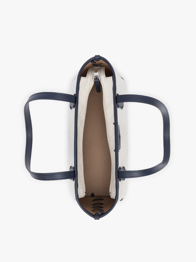 Opened view of CALPAK Colette Canvas Shoulder Tote with zipper  in beige canvas material  and blue finishing