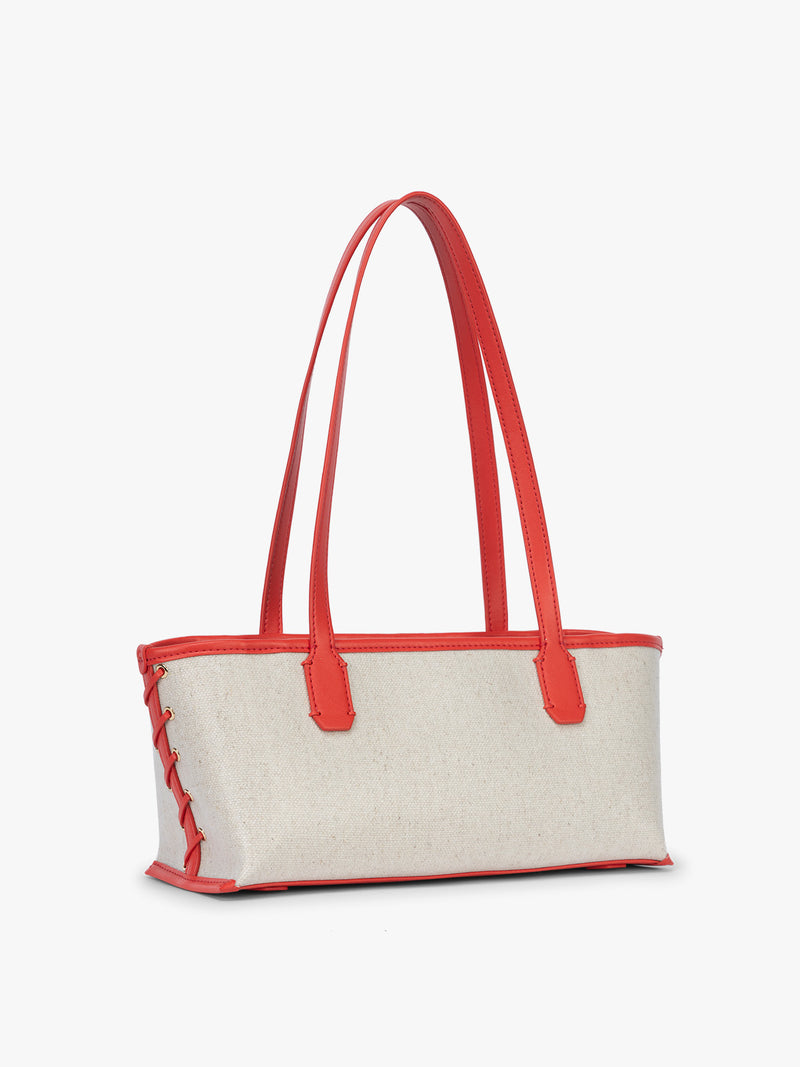 Side view and stitching of CALPAK Colette Canvas Shoulder Tote in beige canvas material and side stitch in red finishing