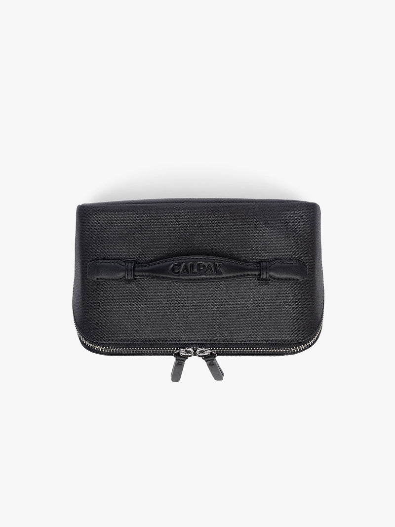 Top view of CALPAK Colette Lay-Flat Canvas Toiletry Bag in black canvas material