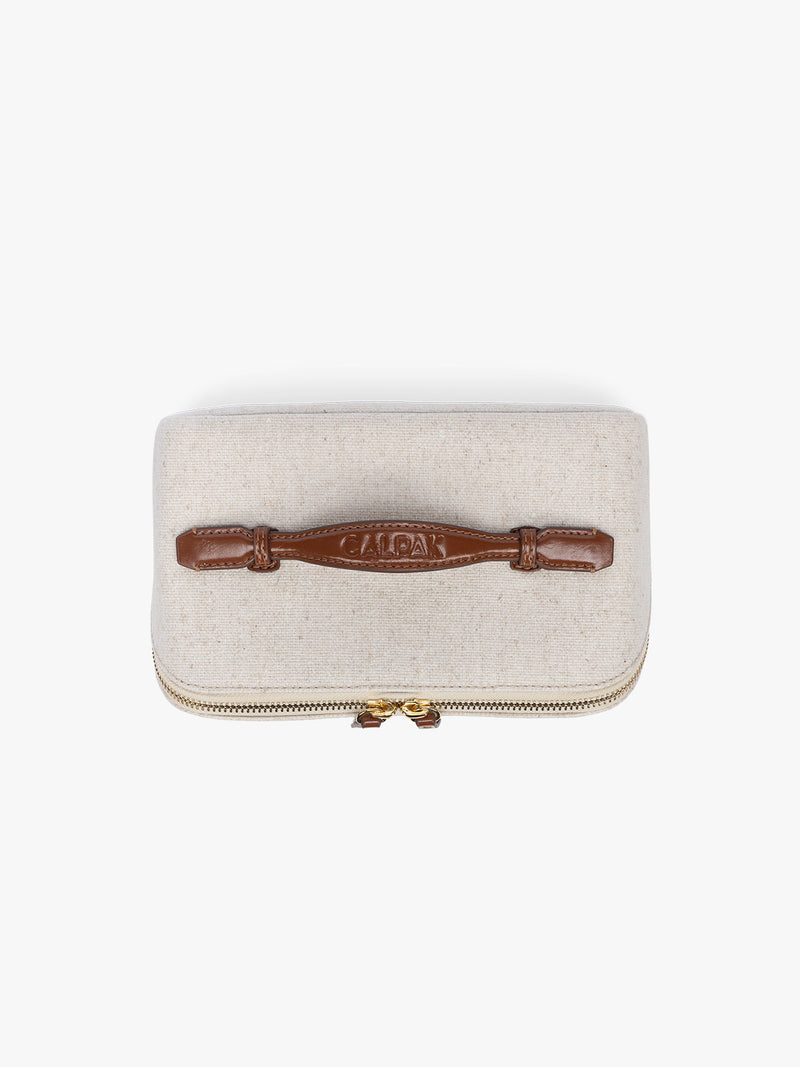 Top view of CALPAK Colette Lay-Flat Canvas Toiletry Bag in beige canvas  material and brown finishing