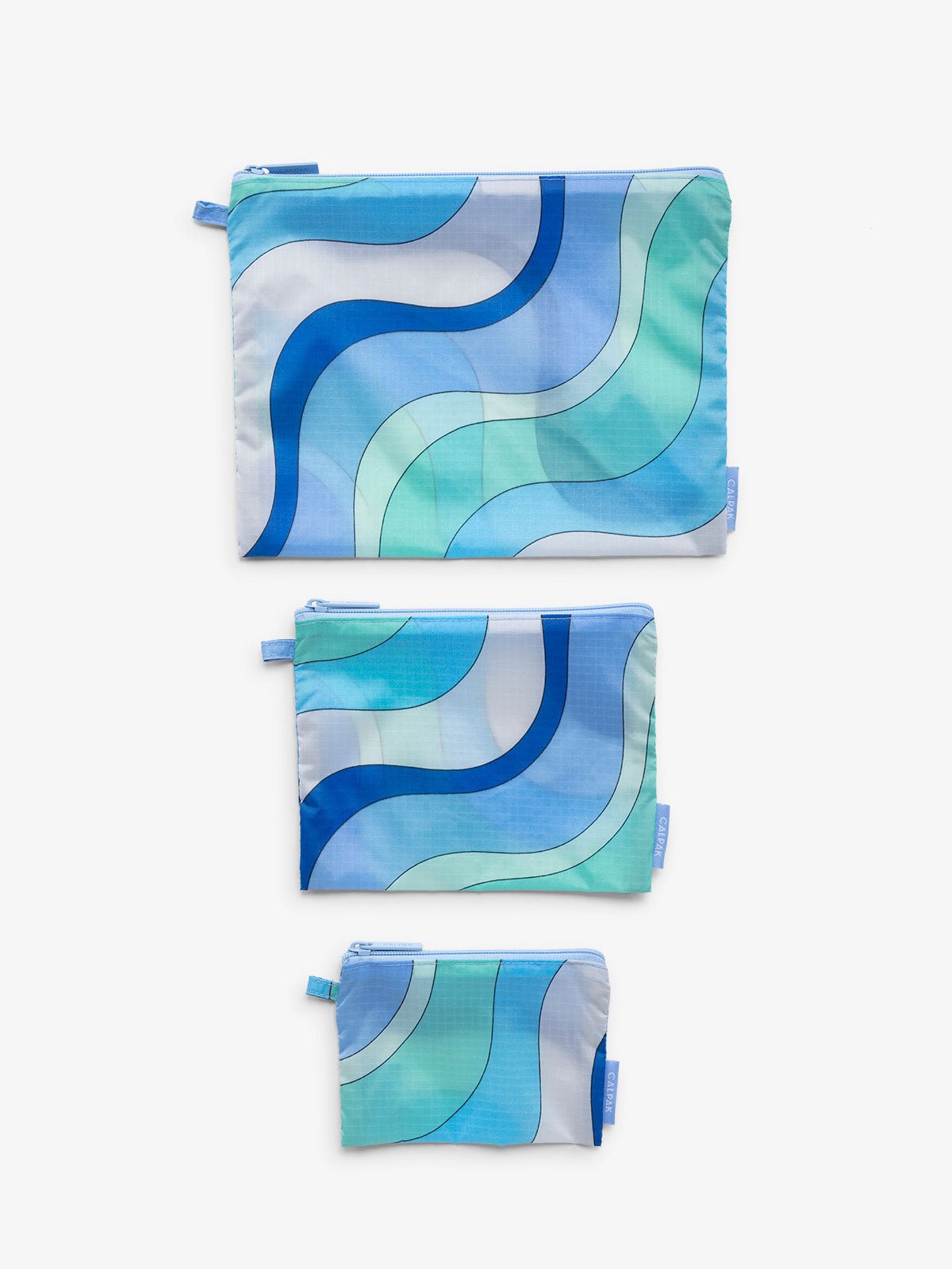 3 sizes of storage pouch for luggage organization Product shot of CALPAK's Compakt collection in 'Groovy Blue', showcasing all three sizes of zippered nylon pouches lying flat in ascending order of size.; KZB2001-GROOVY-BLUE