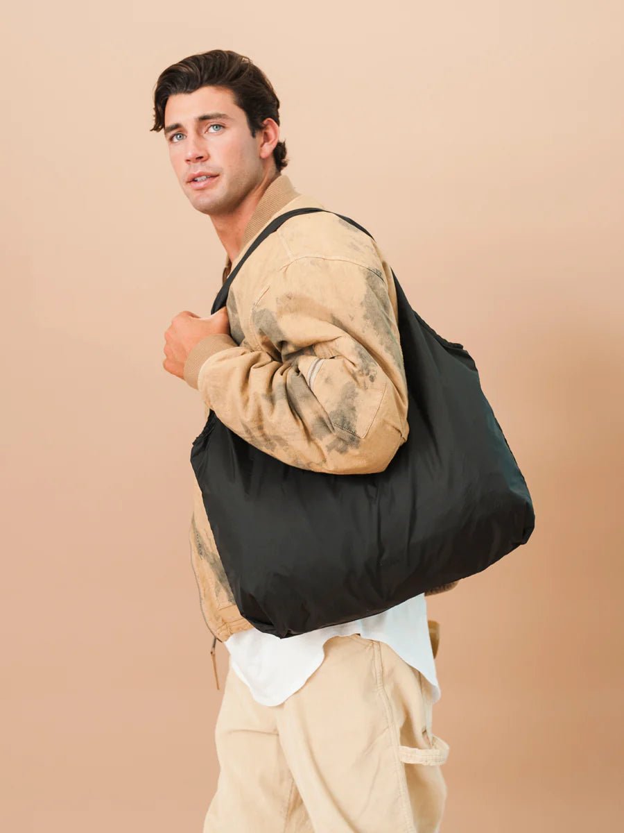 Model with CALPAK Compakt Tote Bag part of compakt duo over shoulder in black