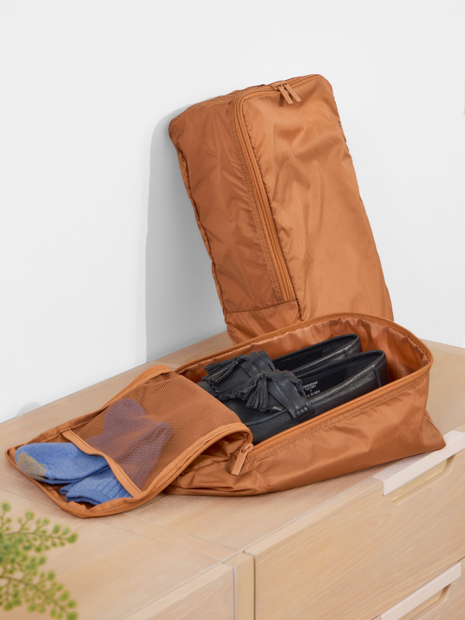 CALPAK Compakt Shoe Bag with shoes inside main compartments and socks within mesh interior pocket