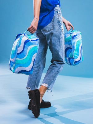 model with holding shoe bag with top handle in groovy blue print