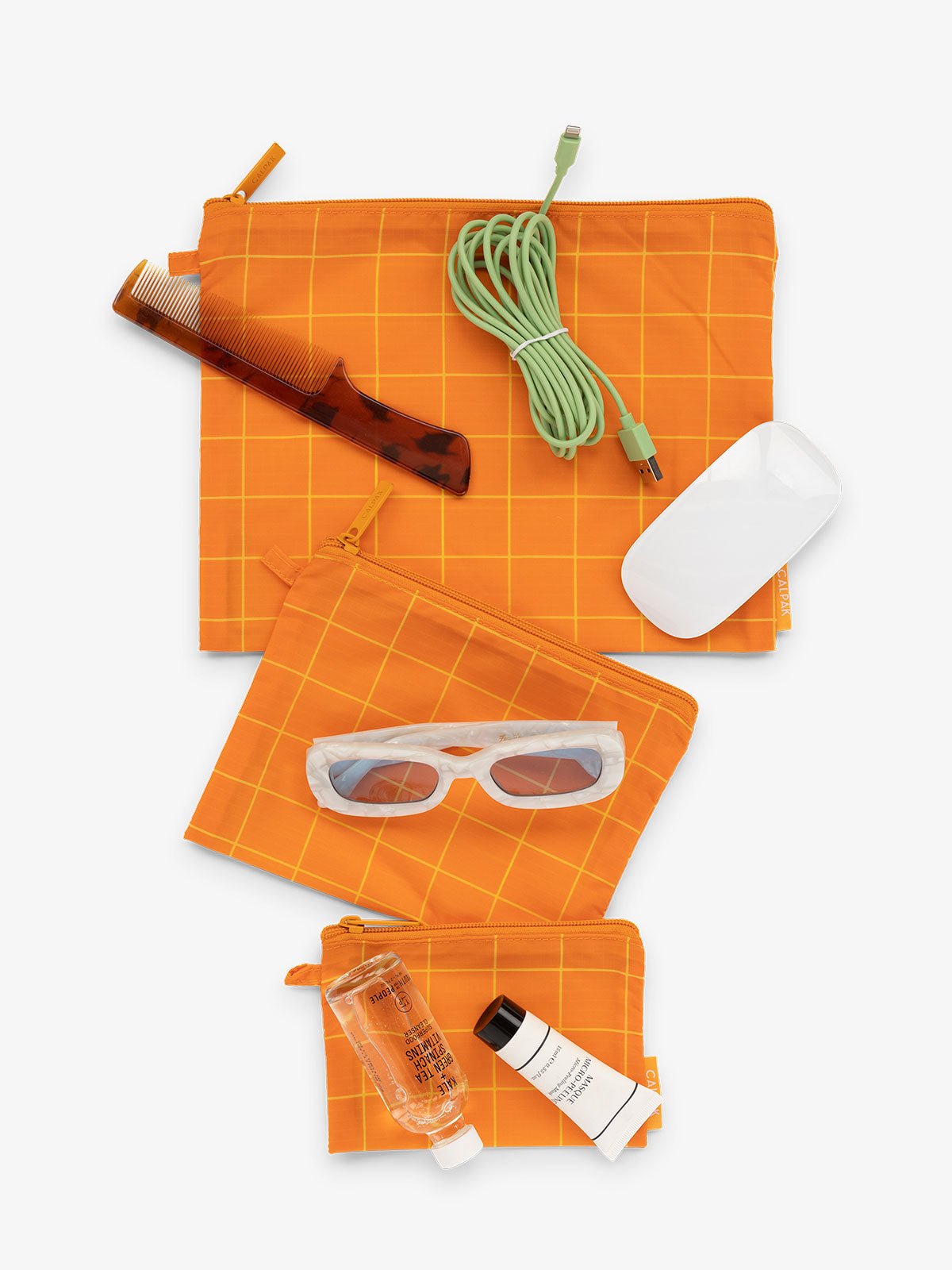 CALPAK Compakt 3 piece zippered pouch set in 3 sizes with water resistant material in orange grid