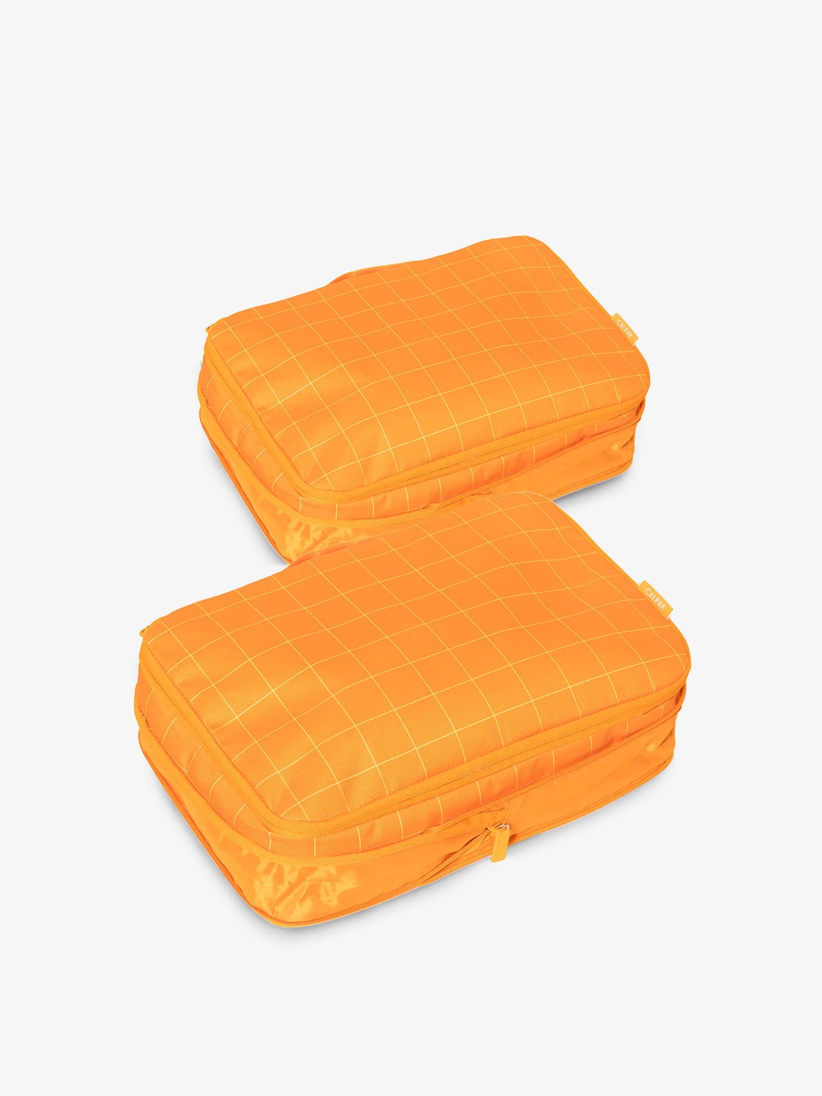CALPAK compression packing cubes with handles in orange grid print