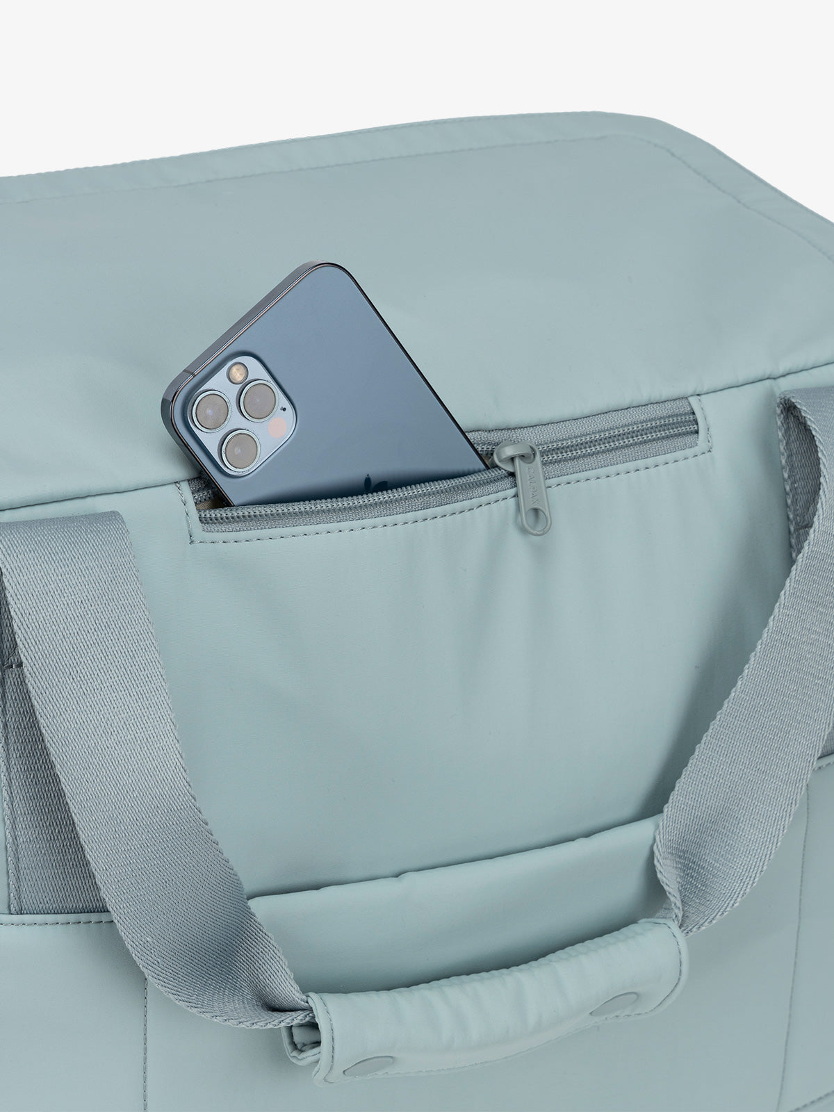 Zippered phone pocket of CALPAK Connect Laptop Duffel in bluebell blue; 
DCN2401-BLUEBELL