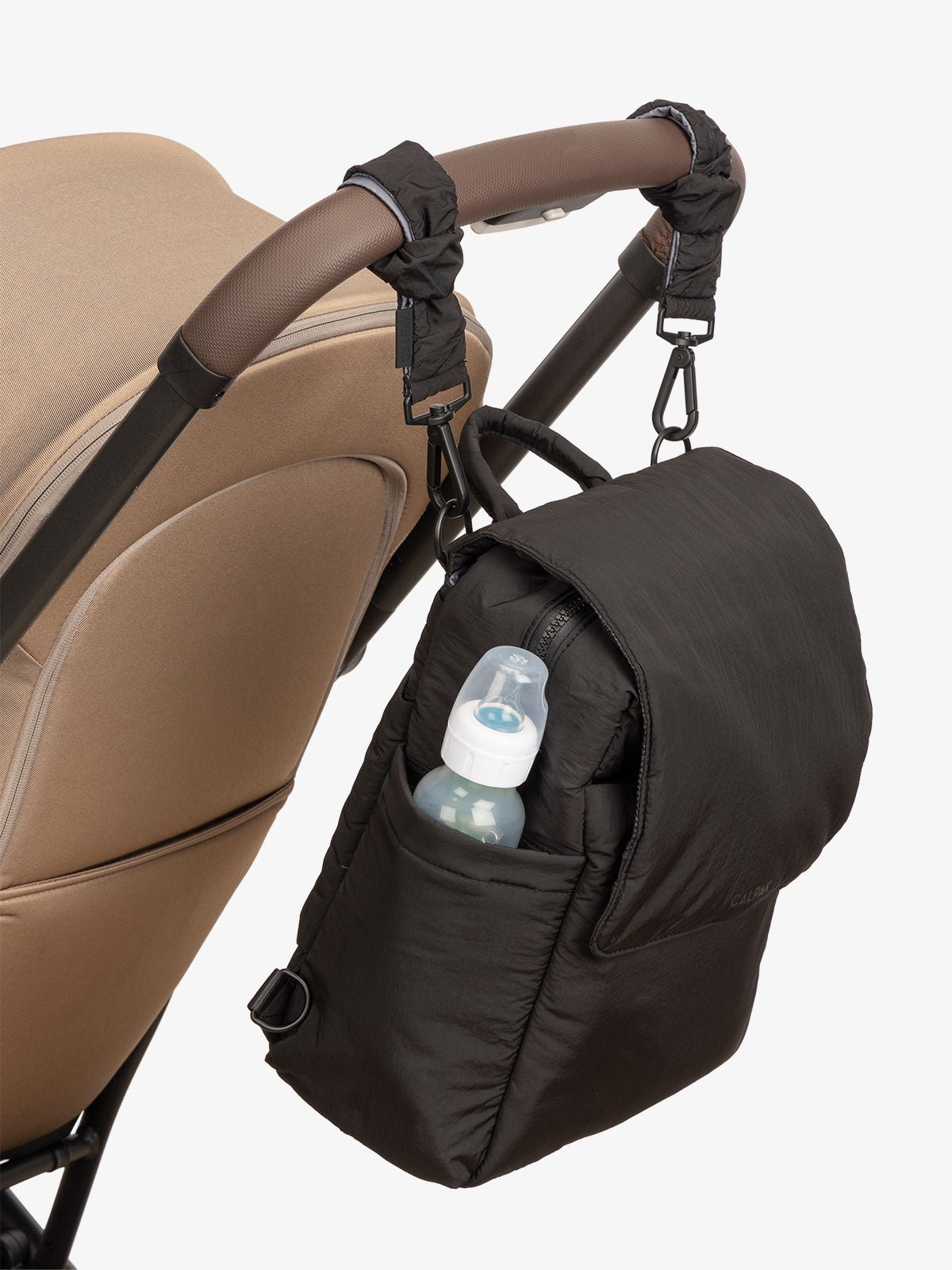 CALPAK Convertible Mini Diaper Backpack attached to stroller by CALPAK Stroller Straps in black