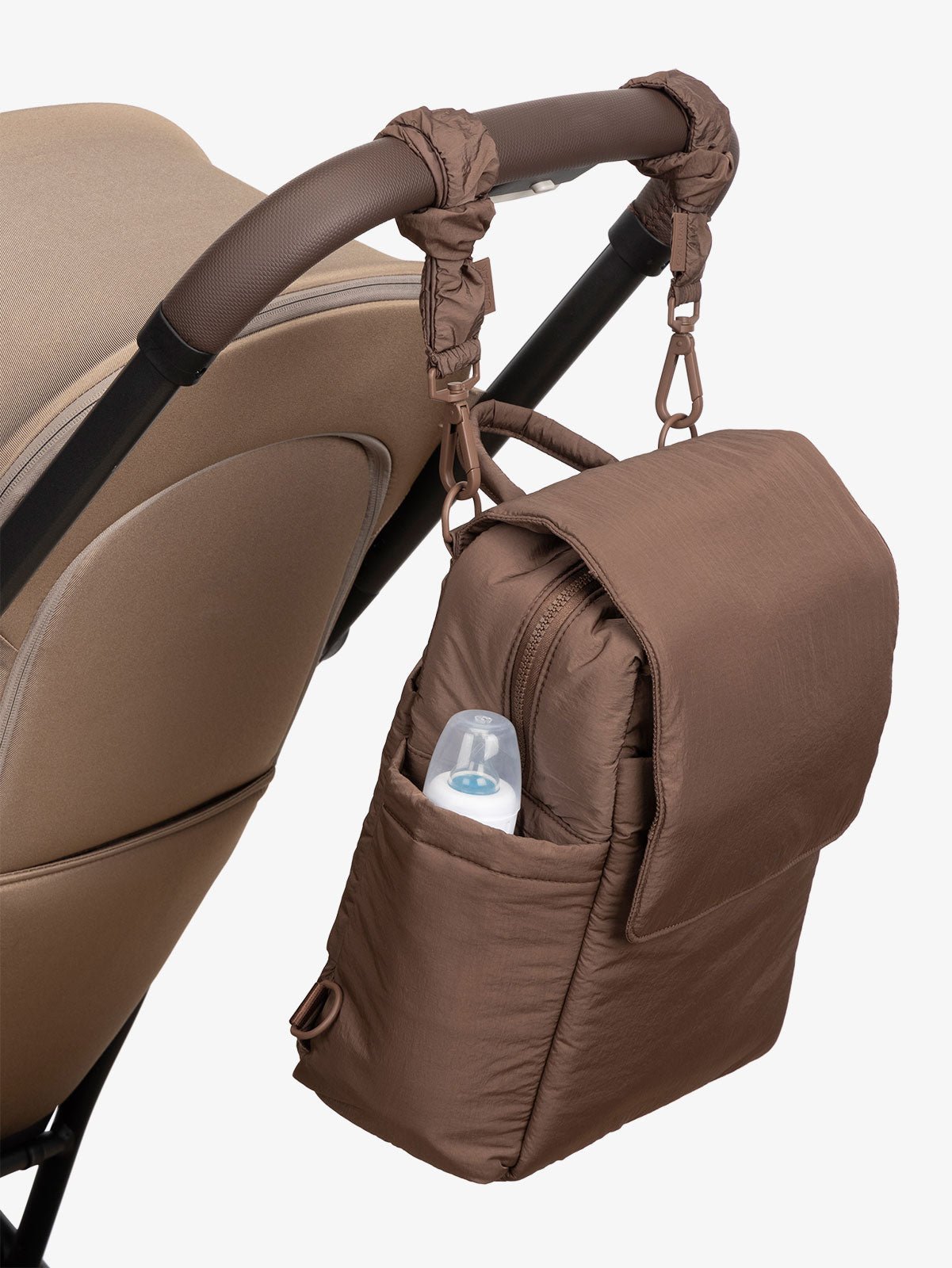 CALPAK Convertible Mini Diaper Backpack attached to stroller by CALPAK Stroller Straps in hazelnut brown