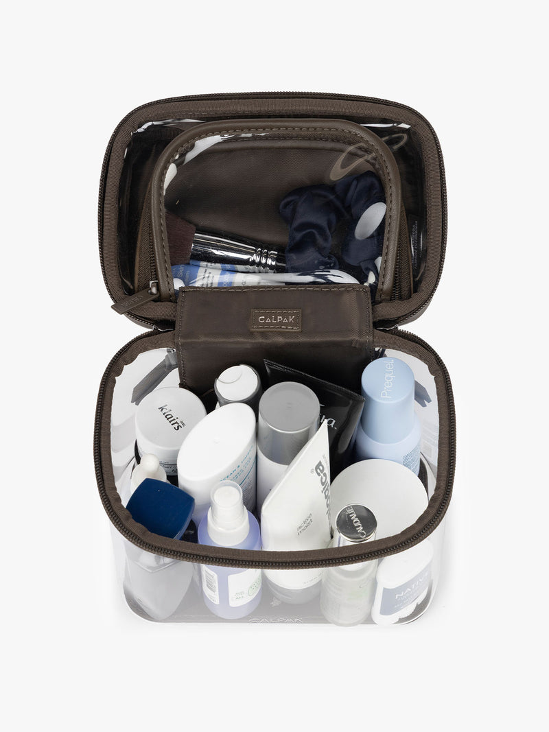 Toiletries inside the CALPAK Clear Train Case in brown Mushroom
