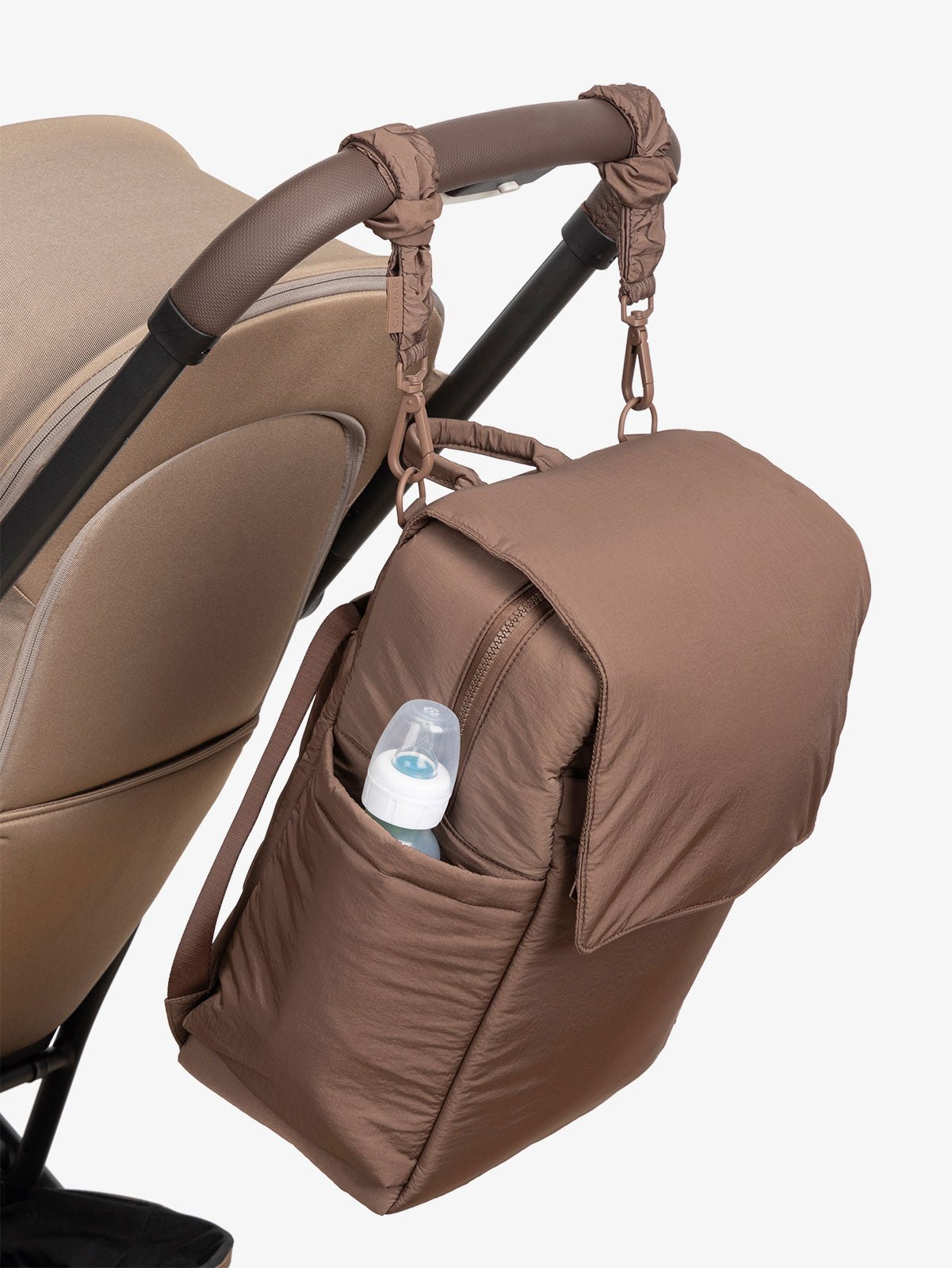 CALPAK Diaper Backpack with Laptop Sleeve attached to stroller by CALPAK Stroller Straps in hazelnut