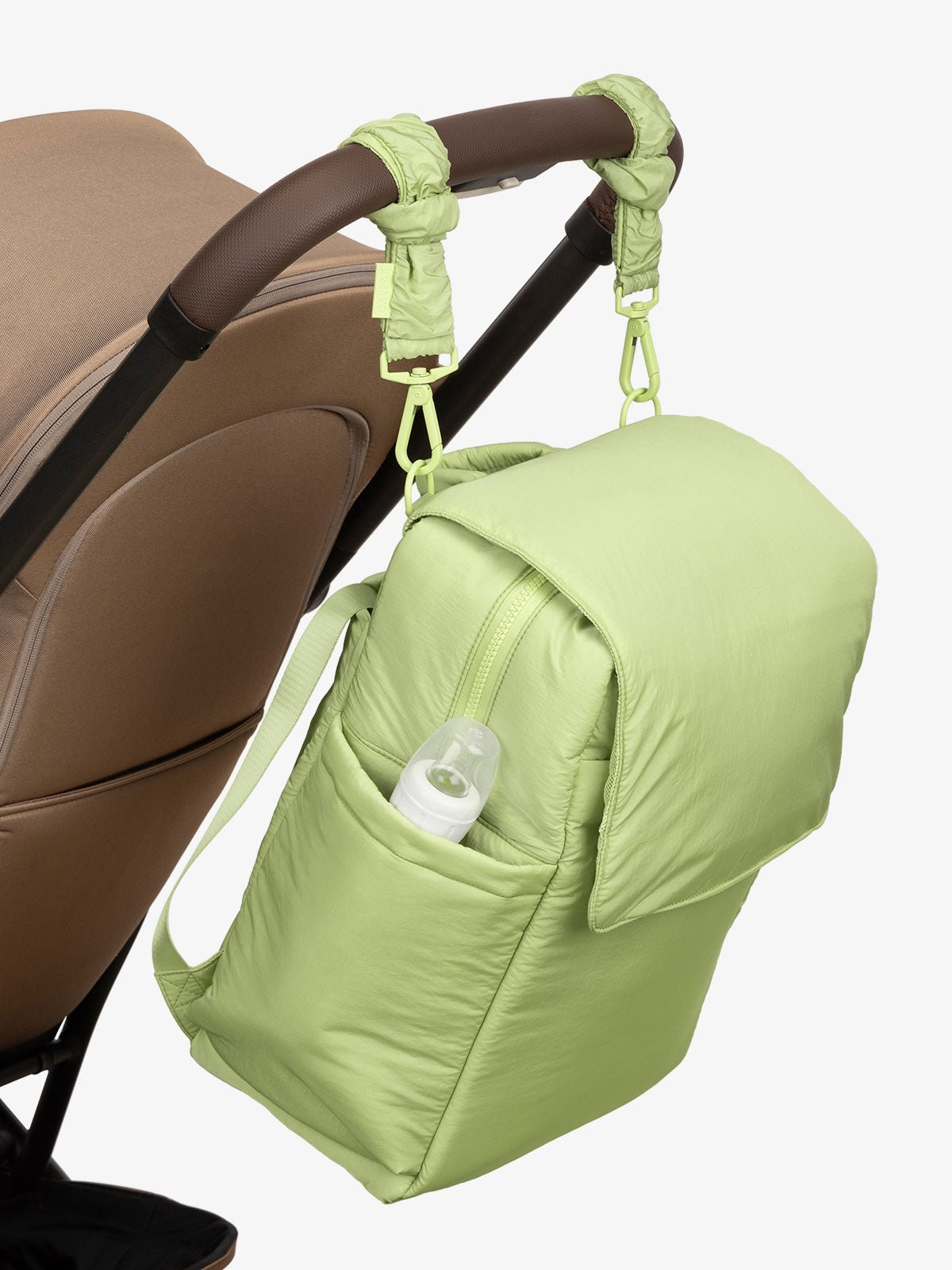 CALPAK Diaper Backpack with Laptop Sleeve attached to stroller by CALPAK Stroller Straps in lime
