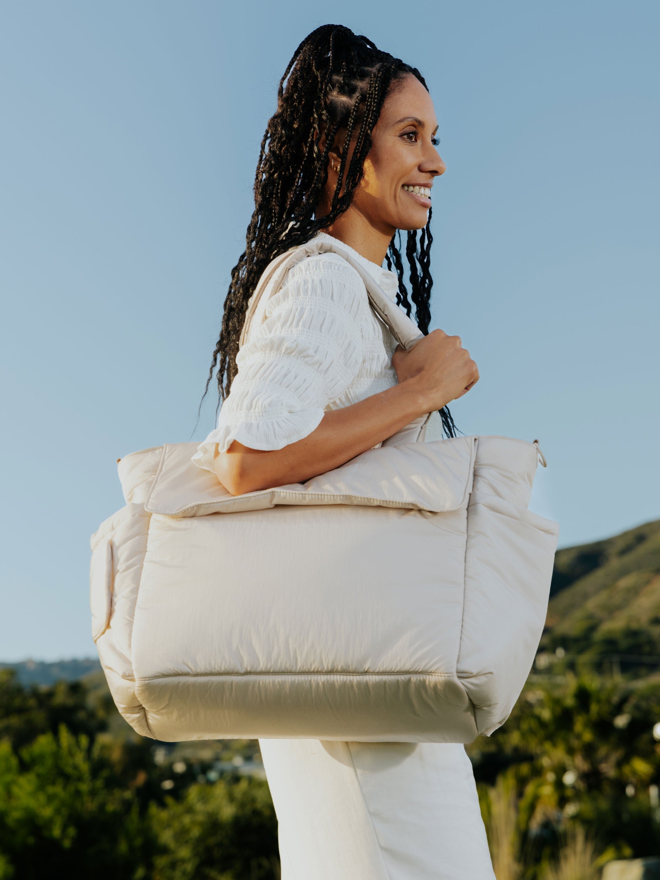 Model wearing CALPAK Diaper Tote Bag with Laptop Sleeve over shoulder in oatmeal