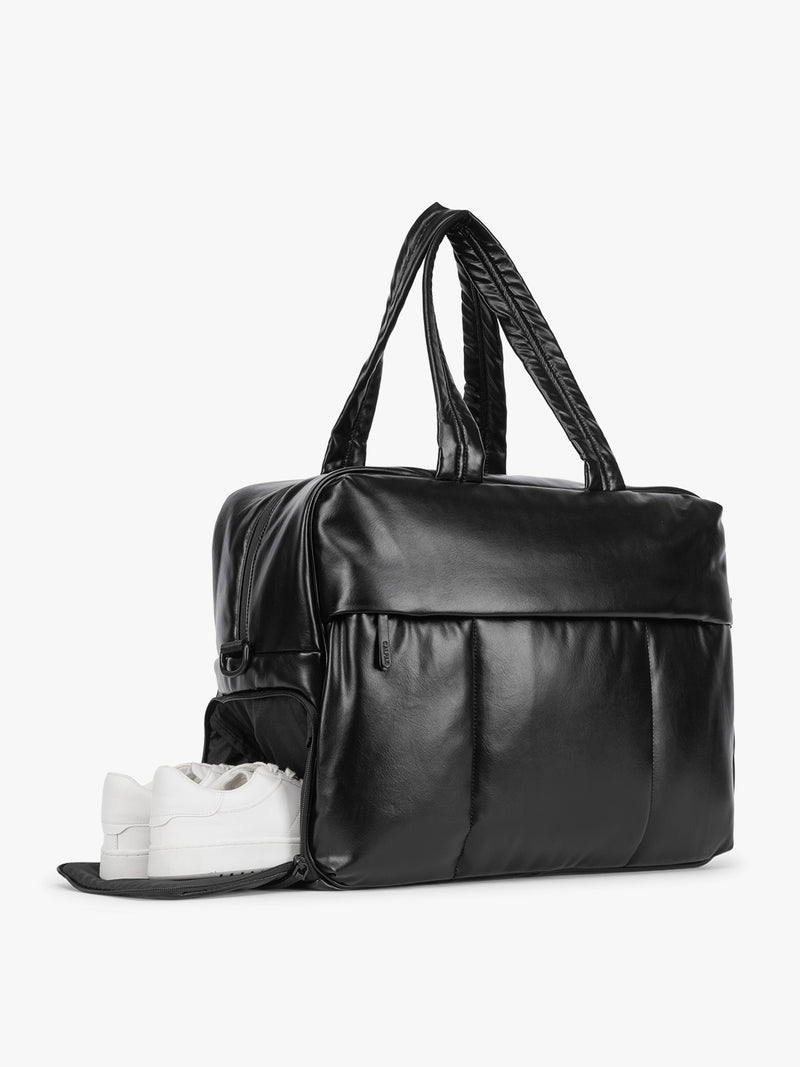 Side shoe compartment of Black CALPAK Luka Large Duffel in vegan leather with dual top handles, shown against a plain white background