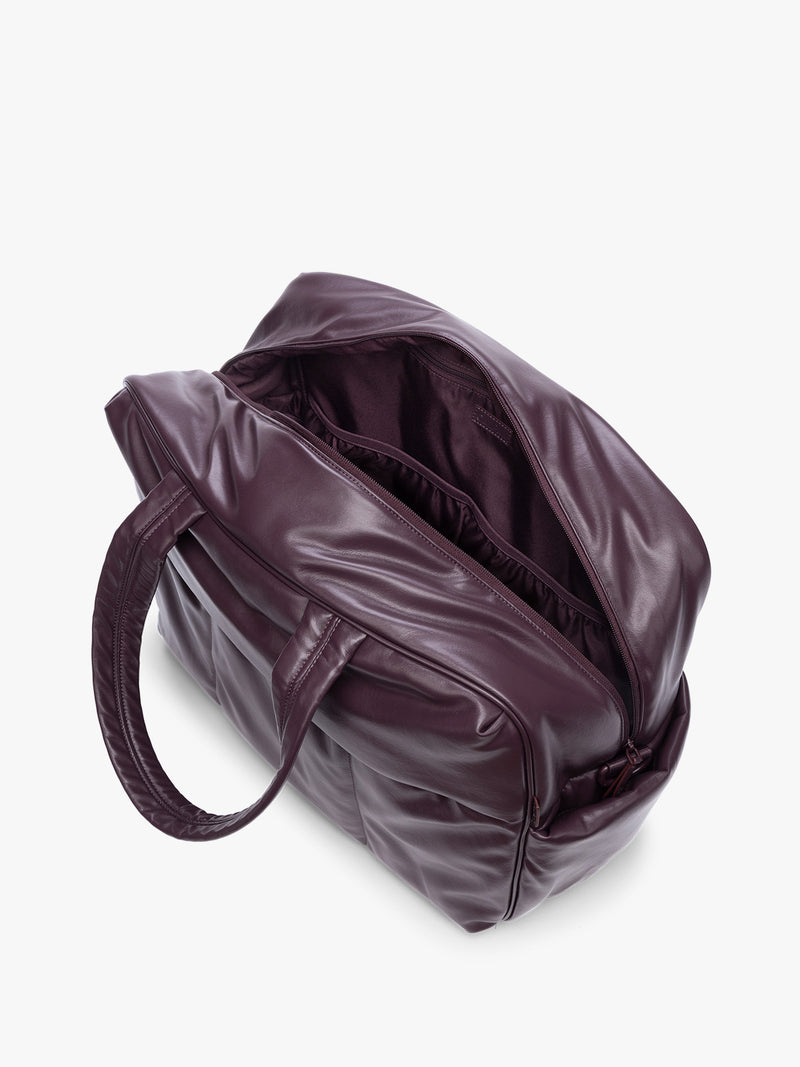 Top view with open zipper showing inside of Dark Cherry deep burgundy CALPAK Luka Large Duffel in vegan leather with dual top handles, shown against a plain white background