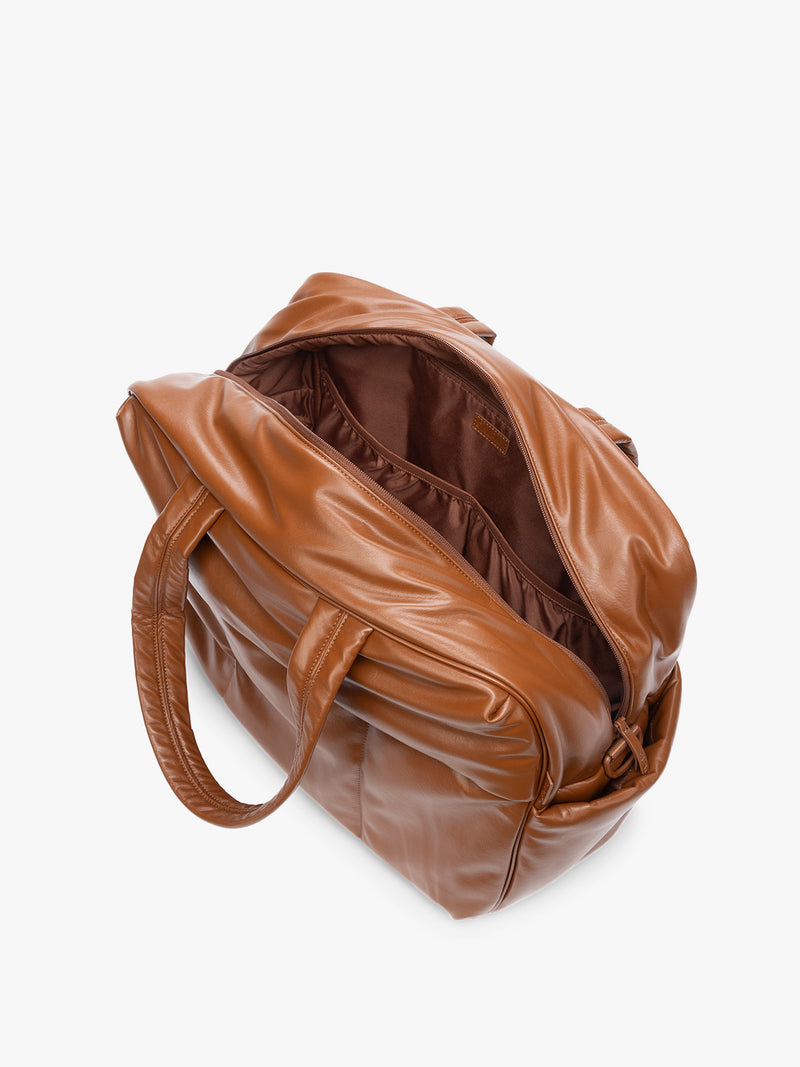 Side view showing inside of Honey Brown CALPAK Luka Large Duffel in vegan leather with dual top handles, shown against a plain white background