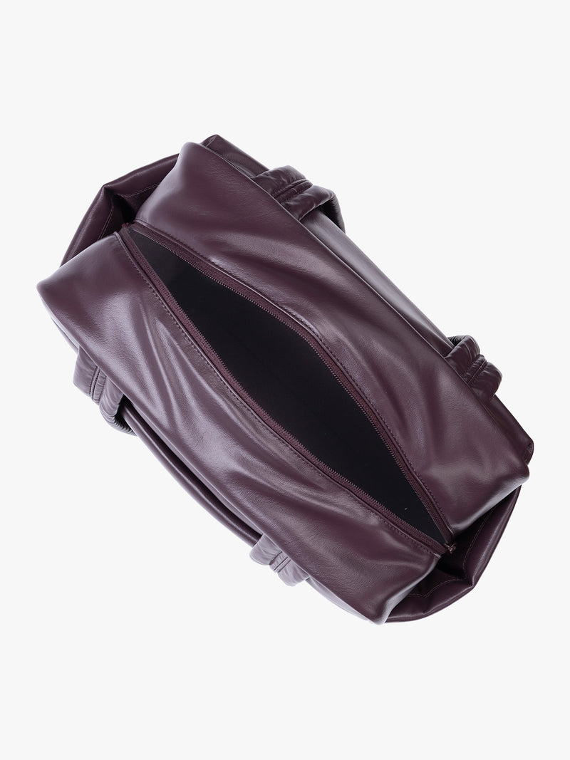 Top view of zipper opened Dark burgundy Dark Cherry vegan leather CALPAK Luka Mini Duffel with dual top handles and side pockets, photographed against a clean white background