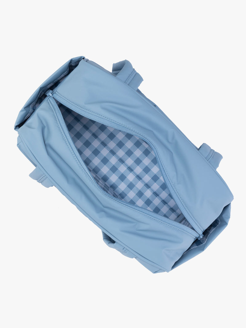 Opened view of CALPAK Luka Mini Duffel in light blue French Blue with white and blue gingham print interior