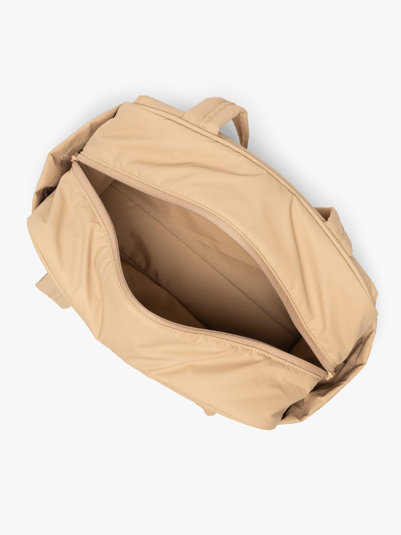 Opened interior of CALPAK Luka Mini Duffel in beige Latte on a white background
