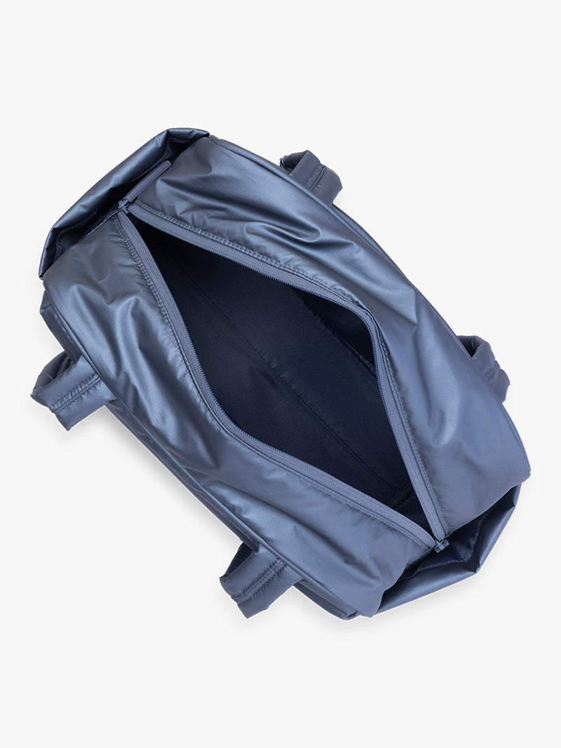 Opened view of CALPAK Luka Mini Duffel in metallic dark blue Metallic Indigo