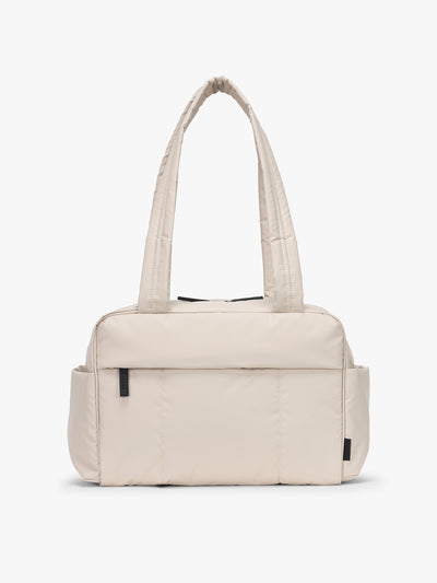 CALPAK Mini Duffel in white Oatmeal front view with puffy exterior, interior and exterior pockets, and padded shoulder straps; DLM2501-OATMEAL view 1