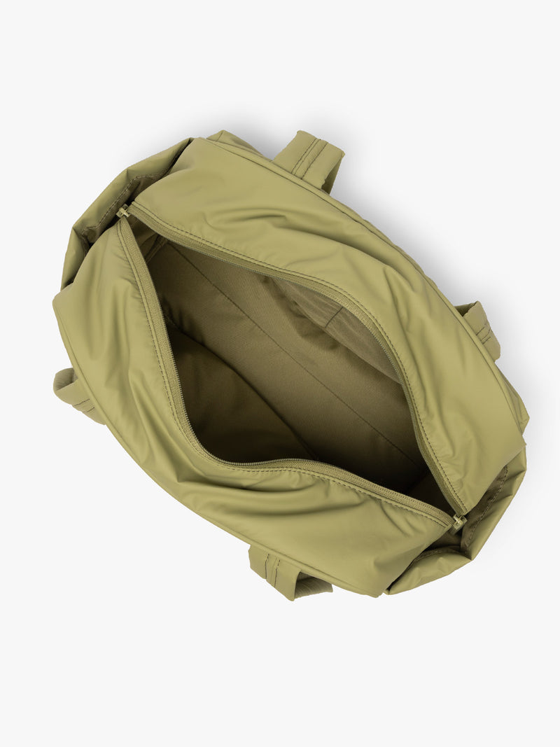 Opened interior of CALPAK Luka Mini Duffel in dark green Pistachio on a white background