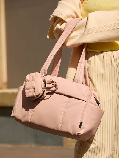 CALPAK Mini Duffel in light pink Rose Quartz with puffy exterior, interior and exterior pockets, and padded shoulder straps; DLM2501-ROSE-QUARTZ view 2