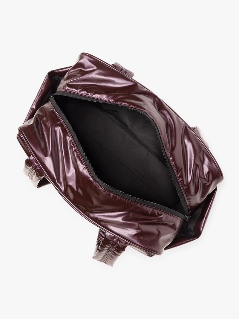 Opened view of CALPAK Luka Mini Duffel in maroon Glazed Dark Cherry on a white background