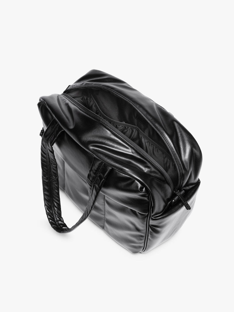 Top view with zipper open showing inside of A Black CALPAK Luka Duffel in vegan leather with dual top handles and a front zippered pocket, photographed against a clean white background